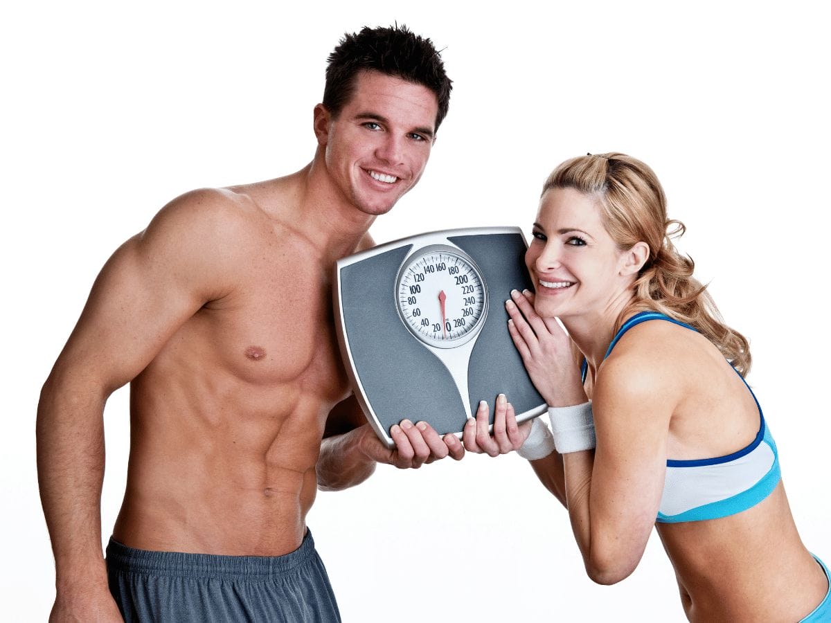 a fit and healthy couple showing a weighing scale