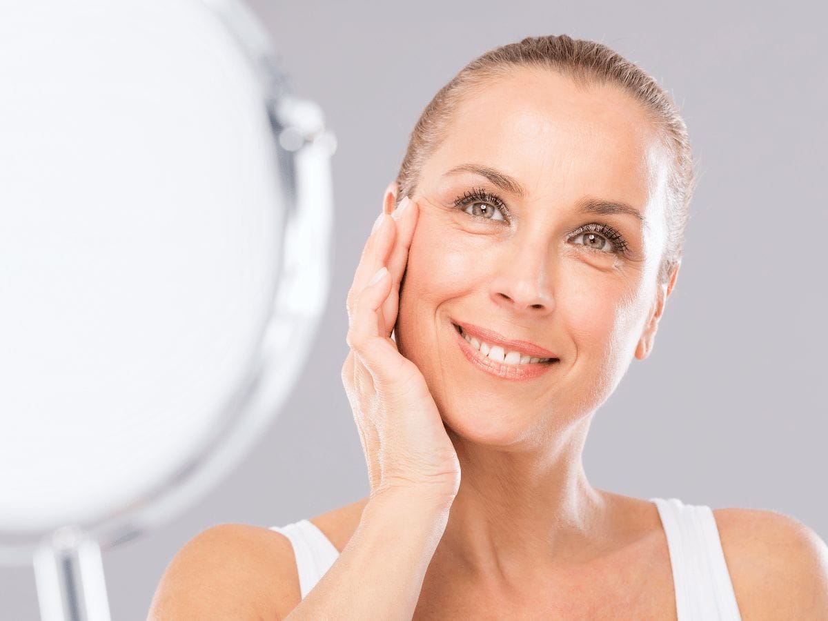 a female patient checking their face after getting anti-aging therapy
