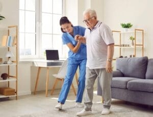 A patient in the recovering phase after surgery being helped by nurse